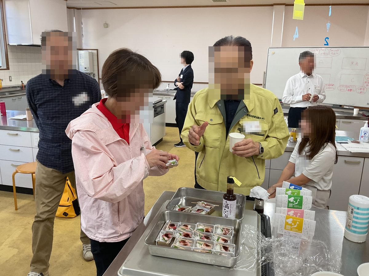 たれをかけた刺身を試食しながら、つくり手の説明を聞く参加者