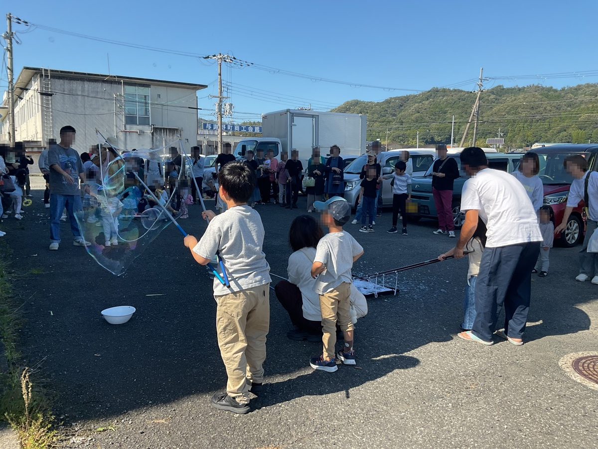 大きなシャボン玉の催しを楽しむ親子
