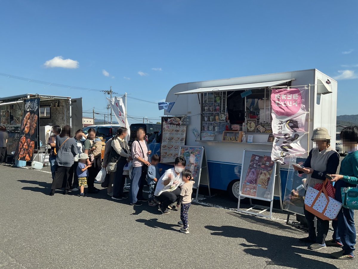 キッチンカーの前に並ぶ家族連れ