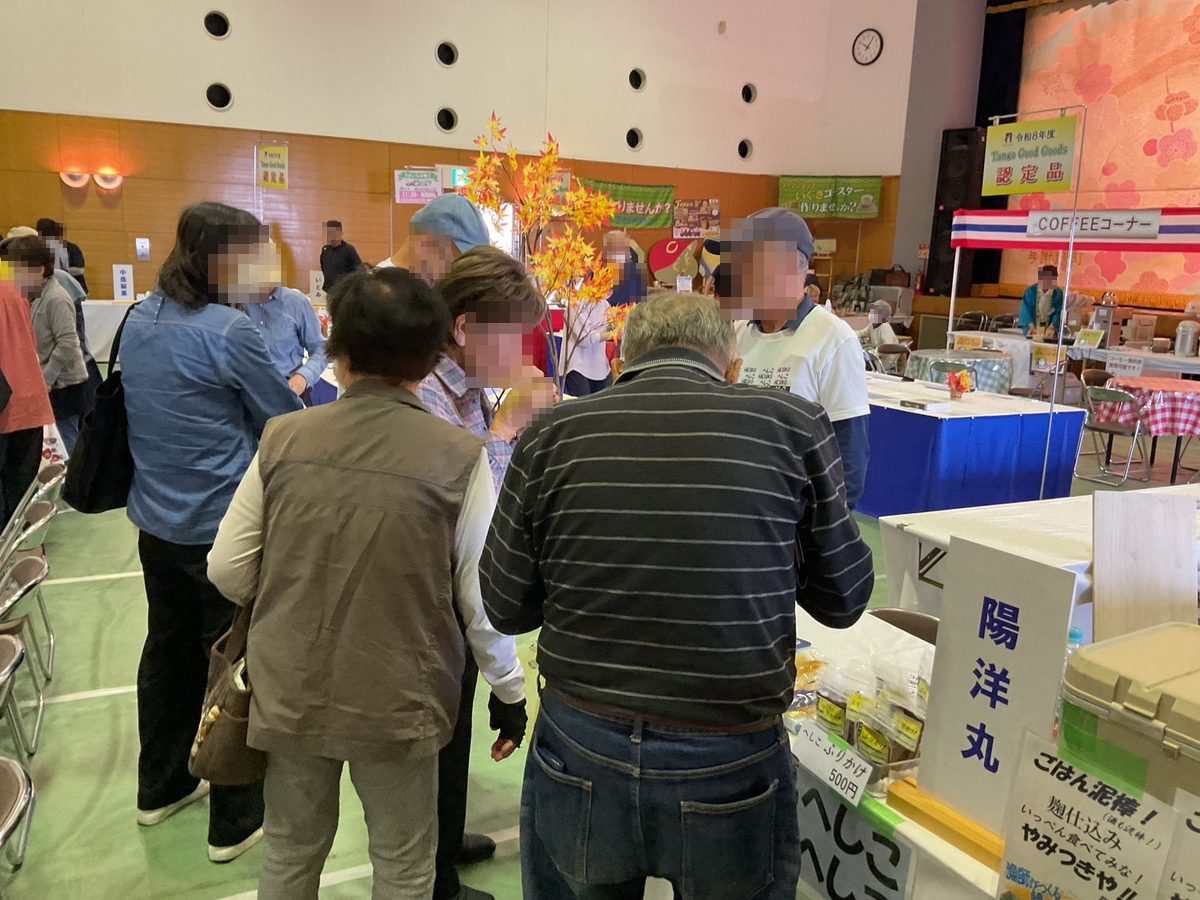 売り場の前で試食しながら話す来場者